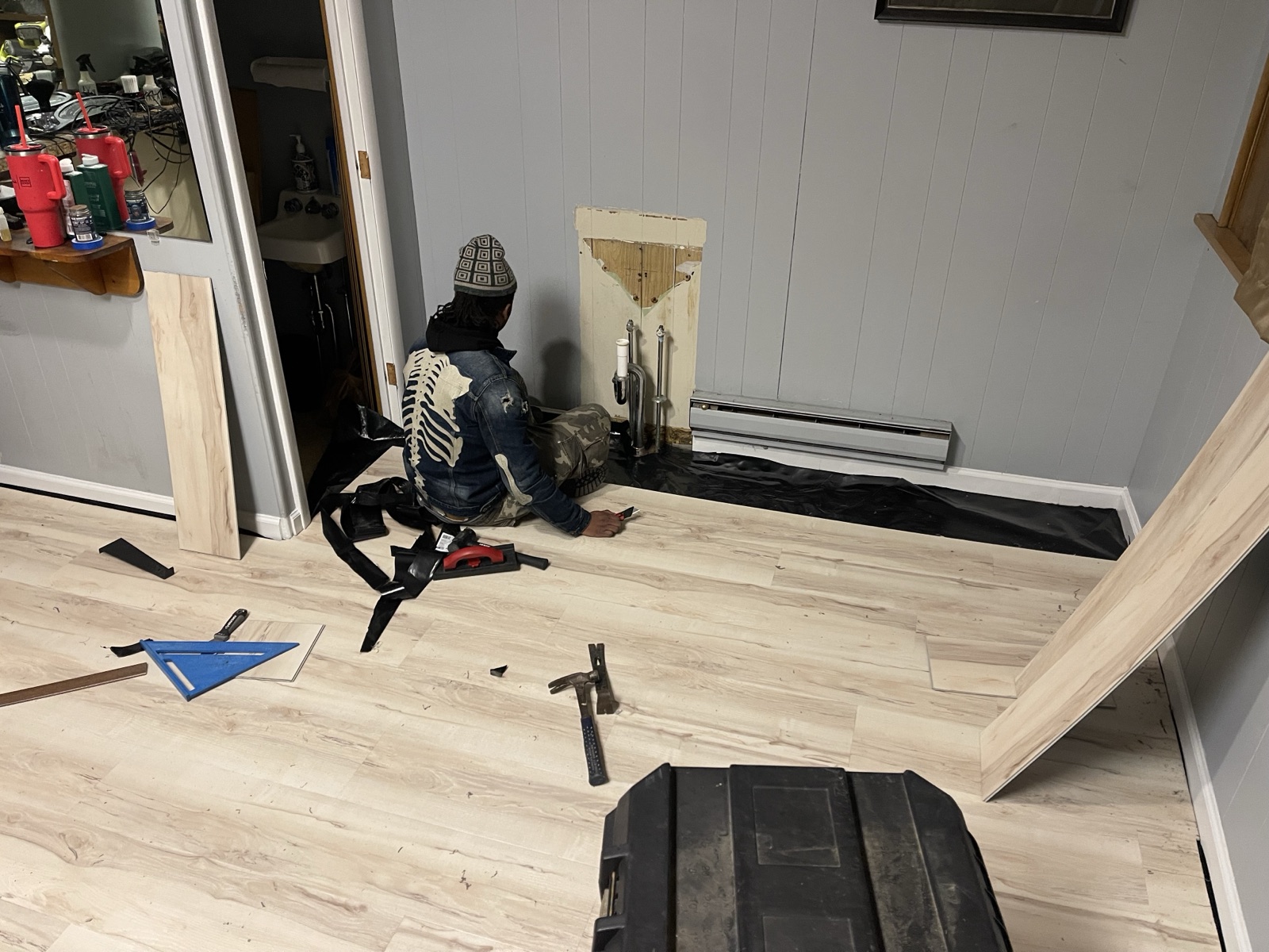 Technician installing vinyl plank flooring in a commercial space