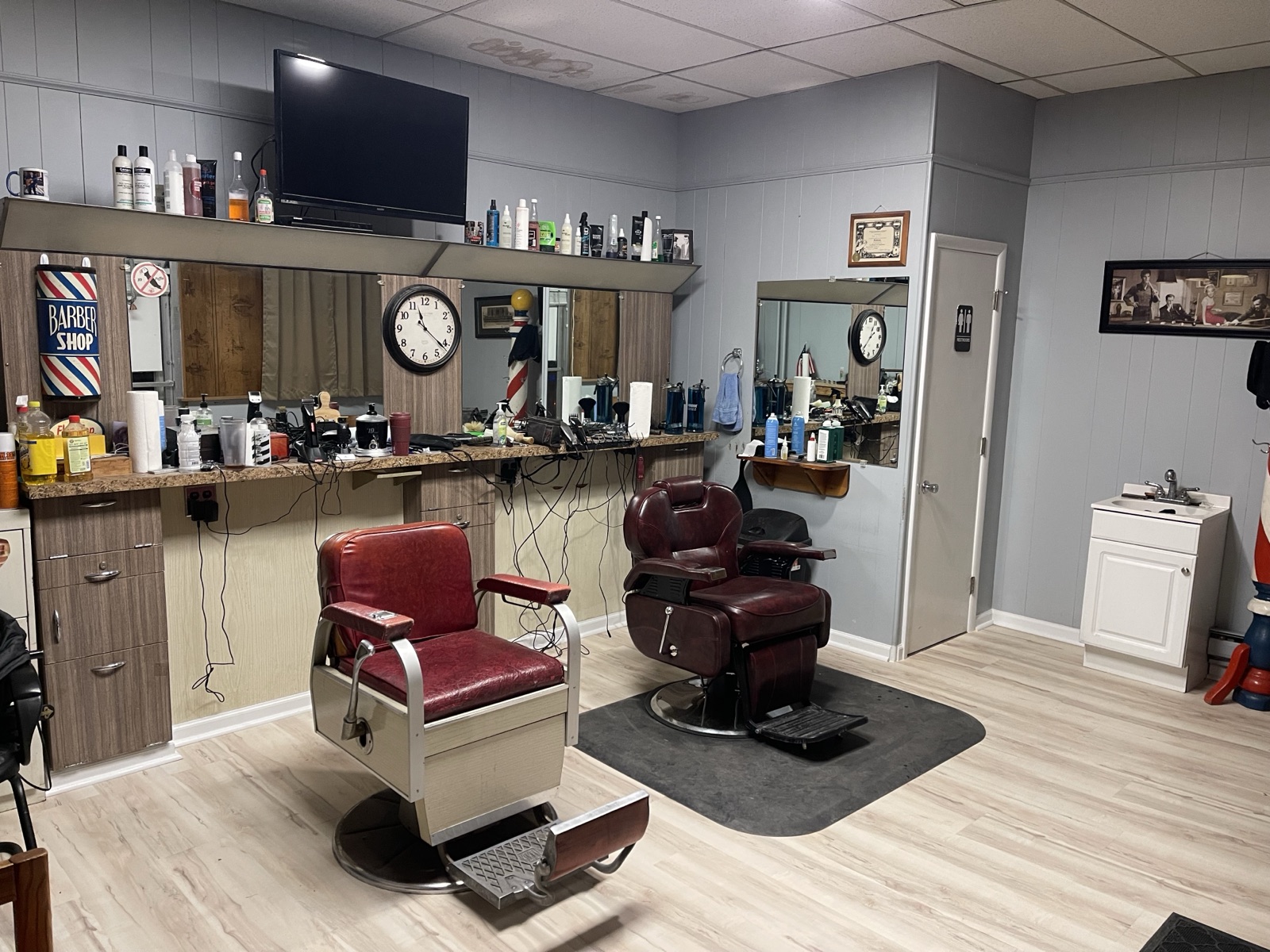 Local barbershop with refinished light plank flooring and vintage chairs