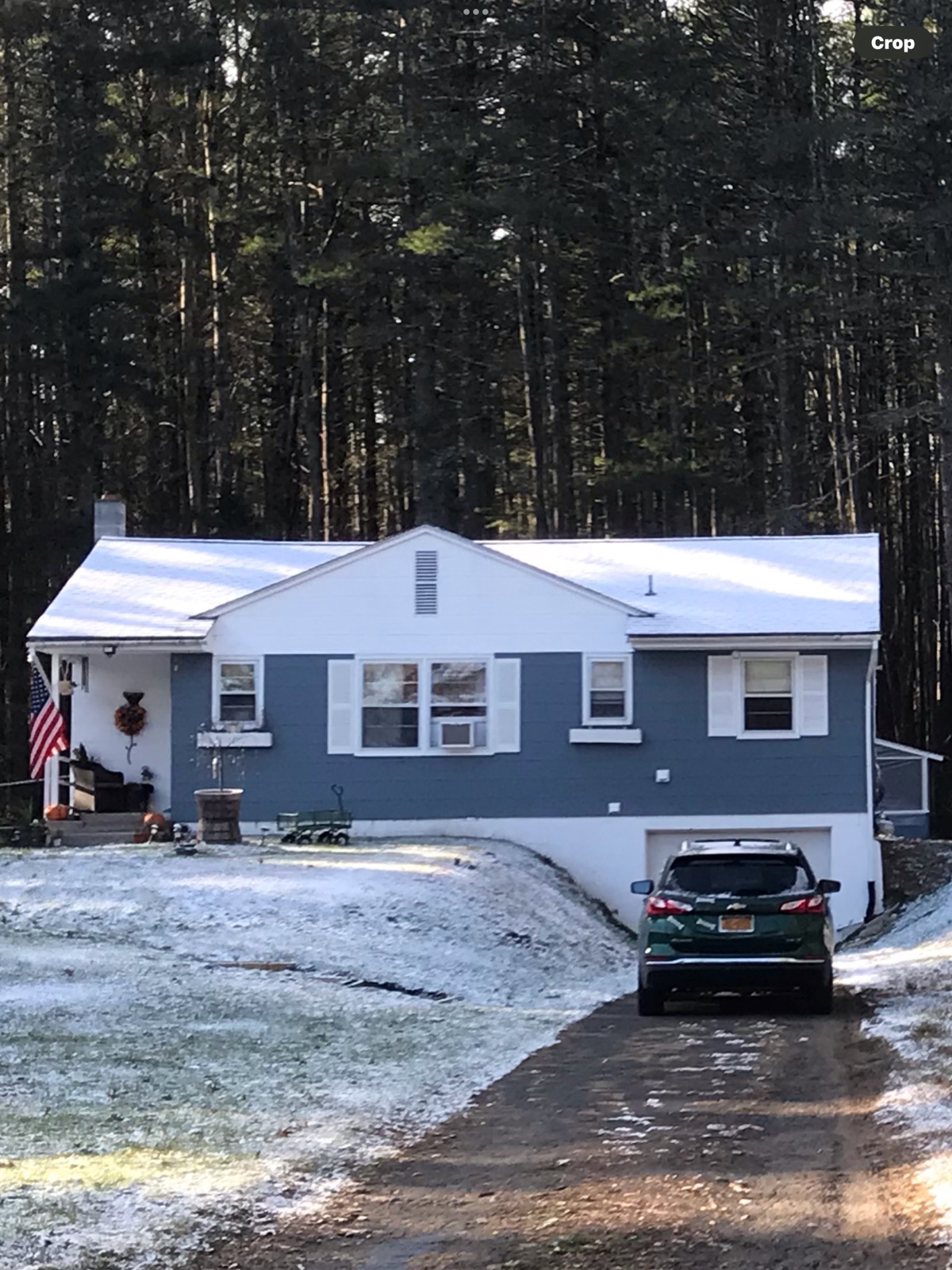 House exterior after renovation with new blue vinyl siding and painted shutters