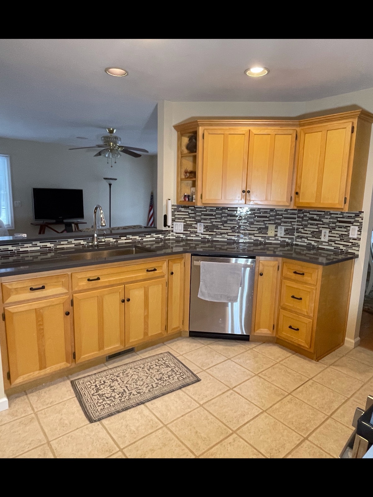 Kitchen with oak cabinets, mosaic glass tile backsplash, and stainless appliances