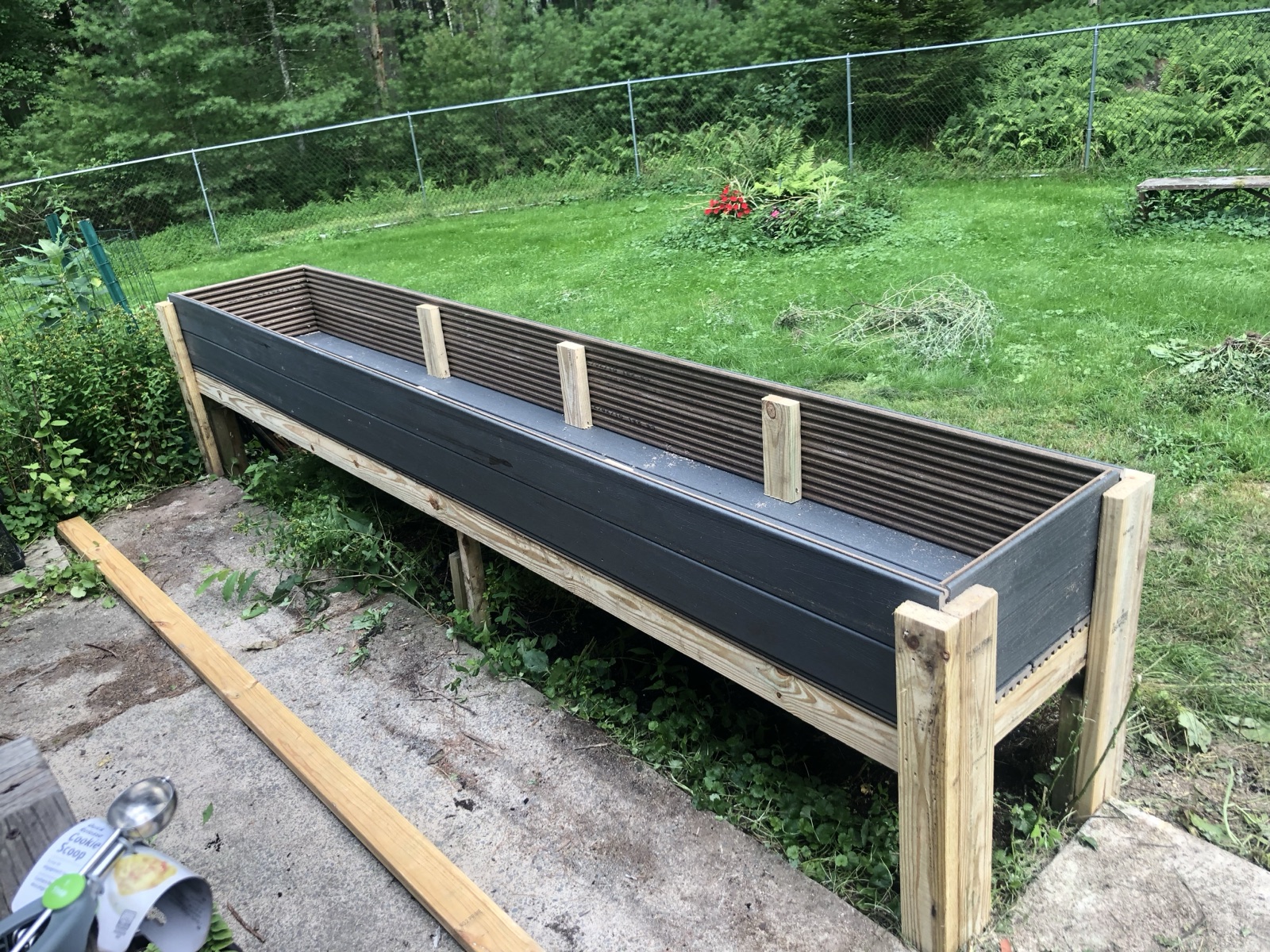 Custom-built elevated wooden planter box in a backyard